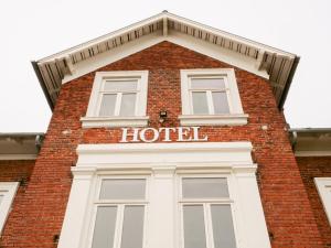 a tall brick building with a hotel sign on it at Hotel Villa Gulle in Nyborg