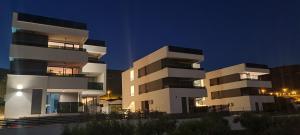 2 immeubles d'appartements blancs la nuit dans l'établissement Penthouse Apartman Marčelina in Trogir, à Trogir
