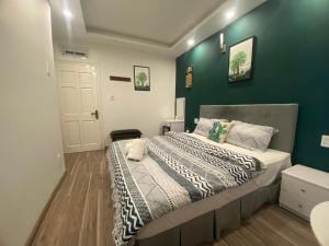 een slaapkamer met een bed met een groene muur bij Lucas Inn in Da Lat