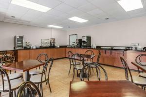 a restaurant with tables and chairs and a kitchen at SureStay Plus Hotel by Best Western McGuire AFB Jackson in Cookstown