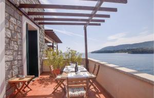 Una mesa y sillas en un balcón con vista al agua. en Casa Azzurra, en Porto Azzurro