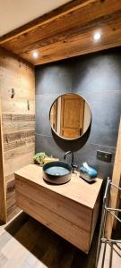 a bathroom with a sink and a mirror on a counter at L'échappée belle Villaroger in Villaroger