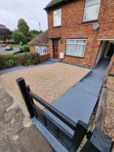 a house with a gravel driveway in front of it at Marahomes in Bushey