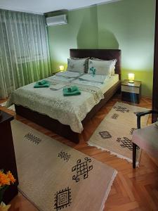 a bedroom with a bed with two rugs on it at Apartman Centar in Bijeljina