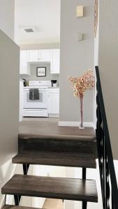 a kitchen with a staircase with a vase of flowers at Lovely 2 Bedroom apartment in Camrose