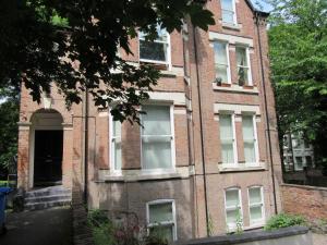 リバプールにあるNo 4 AT SANDRINGHAM - LARGE 2 BED NEAR SEFTON PARKの古いレンガ造りの建物(窓とドア付)