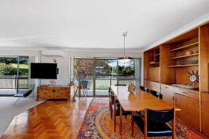 a dining room with a table and a tv at Fi's relaxing Beach House in Port Macquarie