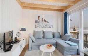 ein Wohnzimmer mit einem blauen Sofa und einem Tisch in der Unterkunft Amazing Home In Ostseeresort Olpenitz With 2 Bedrooms, Wifi And Sauna in Olpenitz