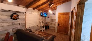 een woonkamer met een leren bank en een televisie bij Cabañas IBY y KIARA para 4 en Puerto Varas in Puerto Varas