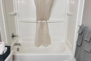 ein Bad mit Dusche und Duschvorhang in der Unterkunft Spacious 2-bedroom apartment in Camrose