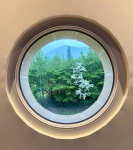 een rond raam met uitzicht op een boom bij Le Loft Occitanie Sud de France in Ceilhes-et-Rocozels