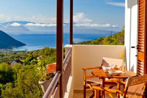 a balcony with a table and a view of the ocean at Calm View in Vasiliki