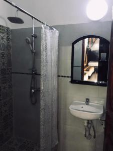 a bathroom with a sink and a shower with a mirror at Riad Al Ârâr in Rabat