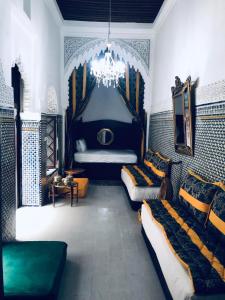 a bedroom with two beds and a chandelier at Riad Al Ârâr in Rabat