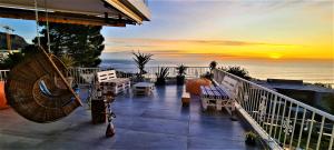 a balcony with a view of the ocean at sunset at African Vibes Camps Bay in Cape Town