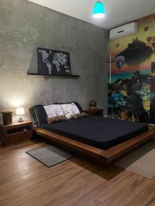 a bedroom with a bed and a painting on the wall at Casa Duplex Aconchegante in Campina Grande