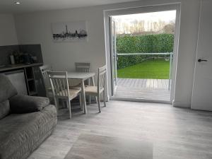 a living room with a table and a sliding glass door at The Welcome Apartment in Blackpool