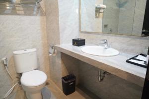 a bathroom with a toilet and a sink at Rylich Panorama Hotel in Sorong