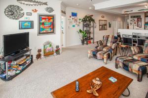 Una sala de estar con un sofá y un televisor. en The Sandbridge Dunes - Katz Meow 204, en Virginia Beach