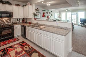 Una cocina con gabinetes blancos y encimera. en The Sandbridge Dunes - Katz Meow 204, en Virginia Beach