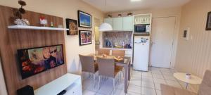 cocina y comedor con mesa y nevera en Gran Lençóis Flat Residence en Barreirinhas