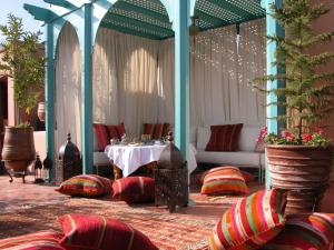 Riad Kniza في مراكش: غرفة مع طاولة وكراسي وطاولة