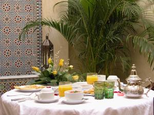 una mesa blanca con comida y bebidas. en Riad Kniza en Marrakech