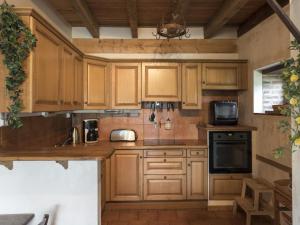 uma cozinha com armários de madeira e um forno com placa de fogão em Gîte Audes, 6 pièces, 10 personnes - FR-1-489-119 em Audes