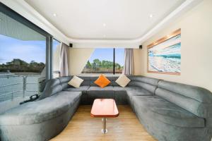 a living room with a large couch and a large window at Coomera Houseboats in Gold Coast