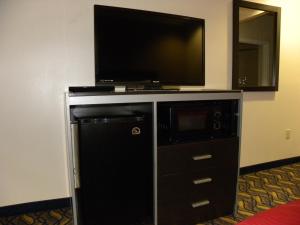 a entertainment center with a flat screen tv on a wall at Palace Inn Kingwood in Humble