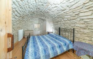 ein Schlafzimmer mit einem Bett in einer Steinmauer in der Unterkunft Lessinia 2 in Selvavecchia