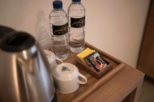 dos botellas de agua sentadas en una mesa con tazas en Artha Cottages, en Sidomukti