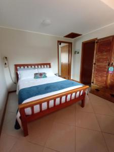 1 dormitorio con cama de madera en una habitación en Casa da Lu Itacoatiara -Apartamento Costão, en Niterói