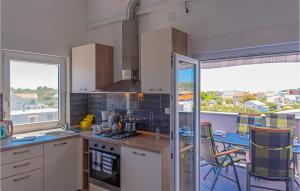 a kitchen with white cabinets and a large window at Stunning Apartment In Kanica With Wifi in Zaglavice