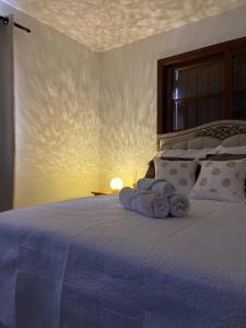 a bedroom with a bed with two towels on it at Chalé House Falkenberg in Monte Verde
