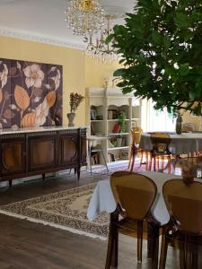 une salle à manger avec une table, des chaises et un lustre dans l'établissement Ziemupes Muiža & SPA, à Ziemupe