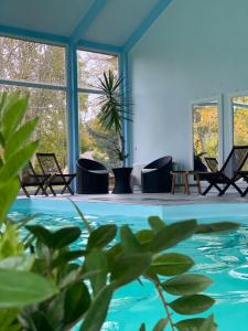een kamer met stoelen en een zwembad bij Ziemupes Muiža & SPA in Ziemupe