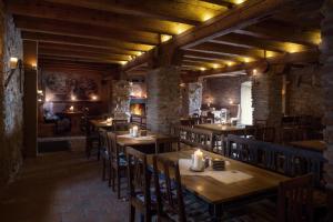 restauracja z drewnianymi stołami, krzesłami i światłami w obiekcie Krčma Hotel U Císařské Cesty w mieście Branišovice