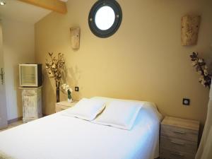 1 dormitorio con cama blanca y ventana en holiday home, Bédarrides, en Bédarrides