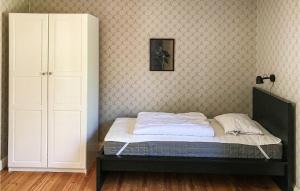 a bedroom with a bed and a cabinet in it at 2 Bedroom Nice Home In Kimstad in Skärblacka