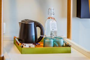 a tea kettle and cups on a kitchen counter at Tjokro Style Yogyakarta in Yogyakarta