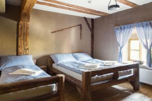 2 camas individuales en una habitación con ventana en Krčma Hotel U Císařské Cesty en Branišovice
