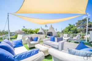 d'une terrasse avec des canapés blancs et des oreillers bleus. dans l'établissement *OPENING PROMO* Luxury 5+1 Bdr Villa 100m To Beach, à Jimbaran