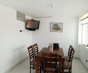 uma sala de jantar com uma mesa e uma televisão na parede em Departamentos Cerro Azul P1 em Cerro Azul