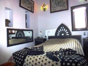 sypialnia z łóżkiem i dużym lustrem w obiekcie Ryad Laârouss w Marakeszu