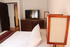 a bedroom with a bed and a tv on a dresser at Casa Gabriel in Cusco