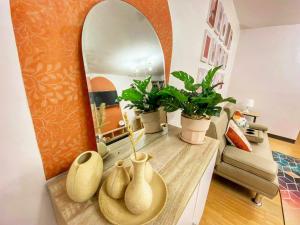 ein Wohnzimmer mit einer Theke mit Vasen und einem Spiegel in der Unterkunft Nordic Themed 1BR Condo - 50 mbps net - Marilao Bulacan - TheRichPlacePh in Marilao