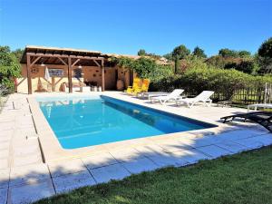 a swimming pool in a yard with chairs and a house at Modern Villa in Saint-Pierre-de-Vassols with Private Pool in Saint-Pierre-de-Vassols