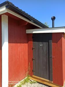un edificio rosso e bianco con due porte di Hannaksen tila a Korpo