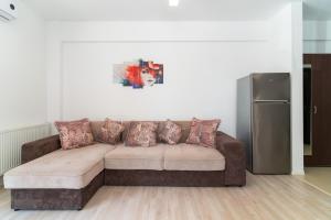 um sofá castanho numa sala de estar com um frigorífico em Apartament Tudor em Mamaia Nord – Năvodari